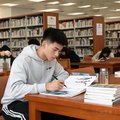 一位年轻男性体育专业大学生在图书馆查阅资料
